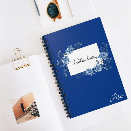 Blue notebook with floral design and 'Notes diary Lisa' text on a white surface.
