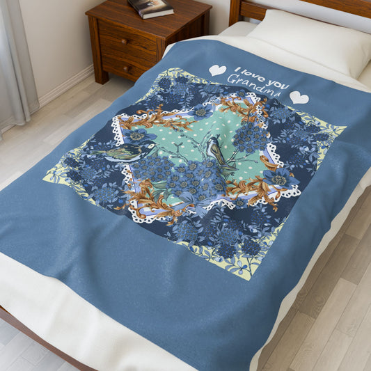 Decorative blanket with nature-themed design and 'I love you Grandpa!' text on a bed.
