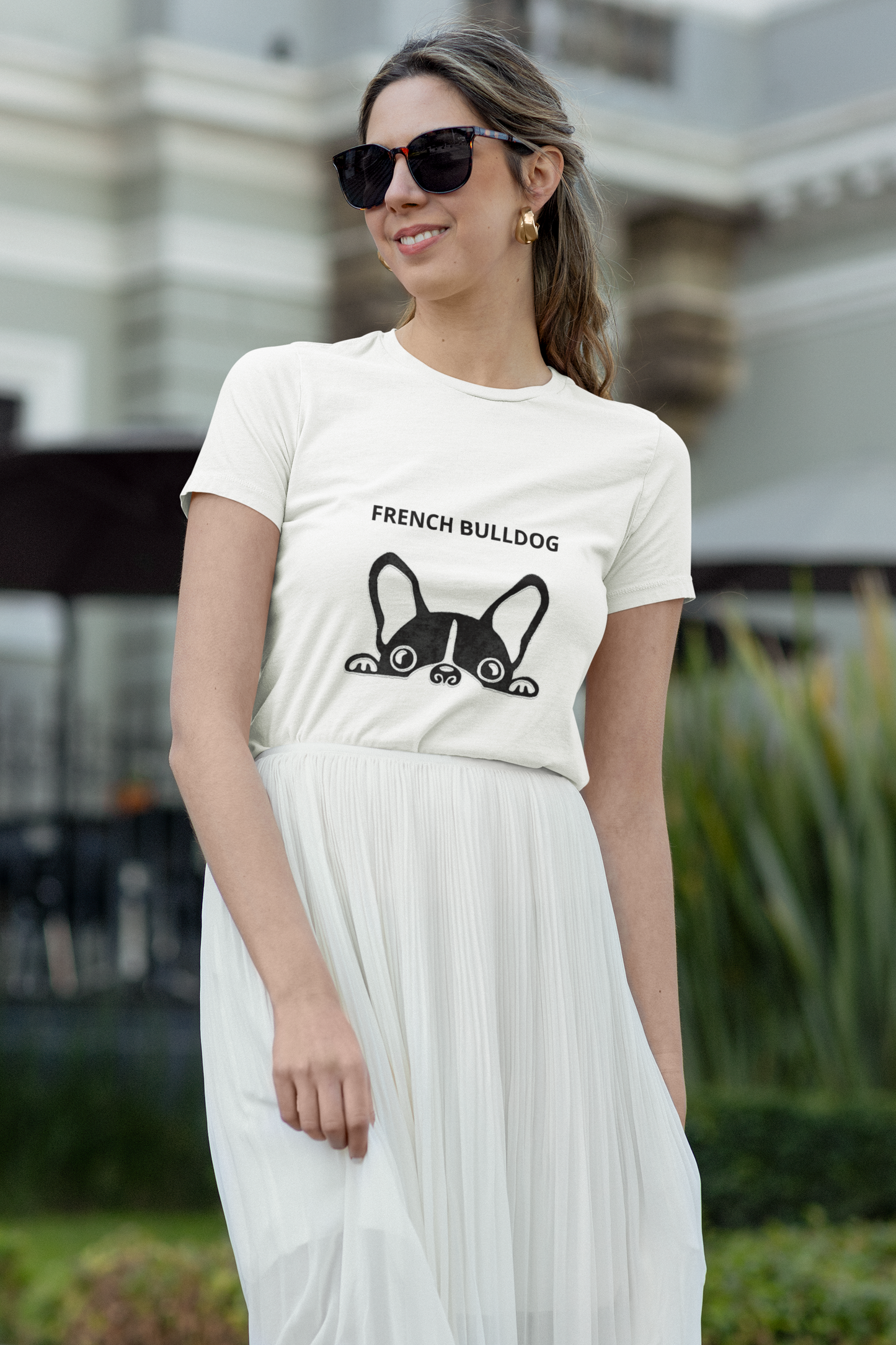 Woman wearing a white t-shirt with a French Bulldog graphic and text, standing outdoors.