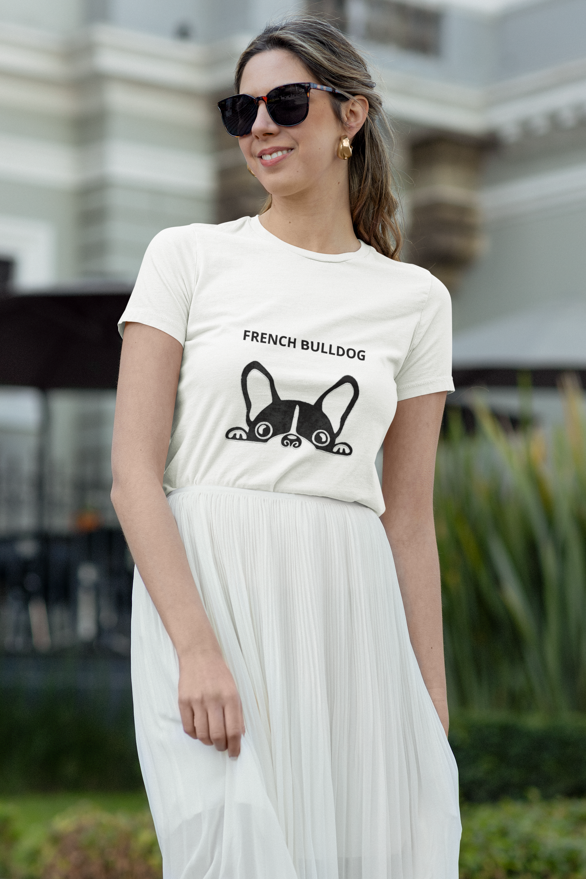 Woman wearing a white t-shirt with a French Bulldog graphic and text, standing outdoors.