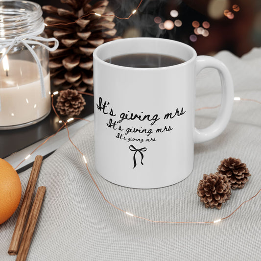 White mug with text on a table with decorative items